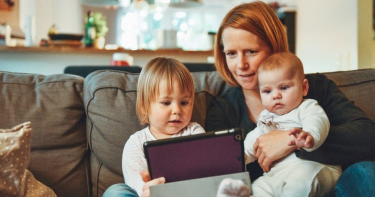 mom and kids looking at tablet