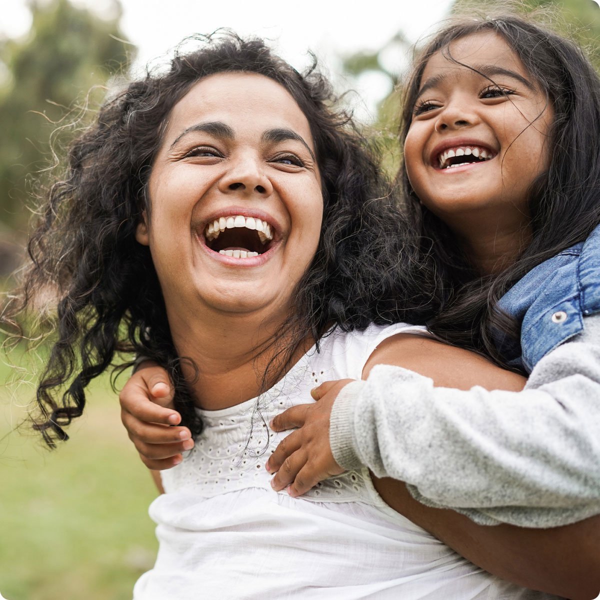 woman with child smiling on shoulders