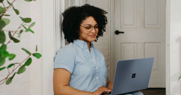 woman on computer sitting smiling